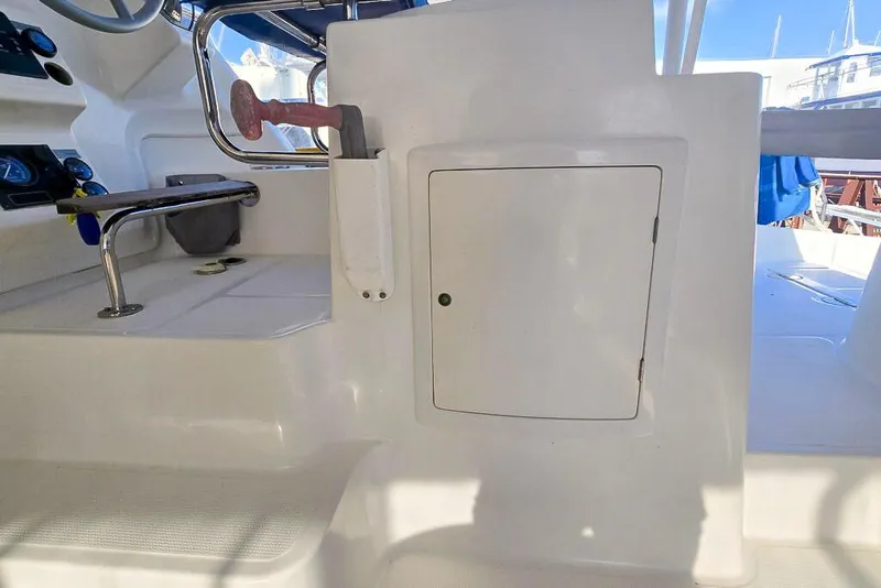 Slide: The Image of Interior of a 2006 Dolphin 460 boat, featuring a storage compartment and control panel. - 29
