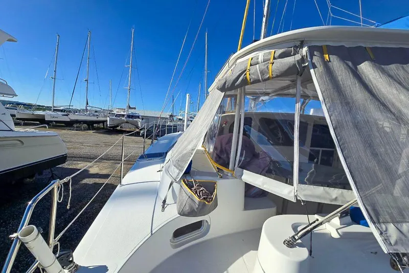 Slide: The Image of Sailboats docked at marina, featuring a 2006 Dolphin 460 catamaran under clear blue skies. - 31