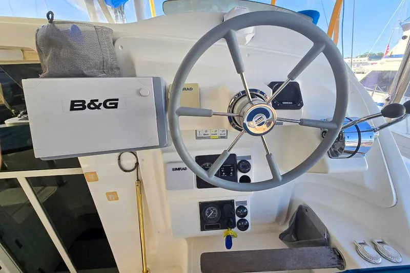 Slide: The Image of Steering wheel and controls of a 2006 Dolphin 460 yacht, featuring B&G navigation equipment. - 33