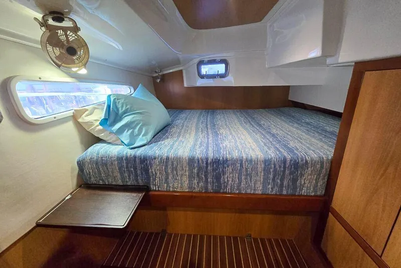 Slide: The Image of Cozy cabin interior of 2006 Dolphin 460 yacht with bed, window, and fan. - 39