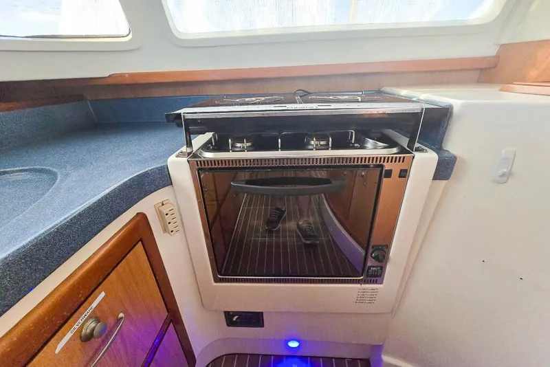 Slide: The Image of Compact kitchen area in a 2006 Dolphin 460 yacht with built-in oven and stove. - 45