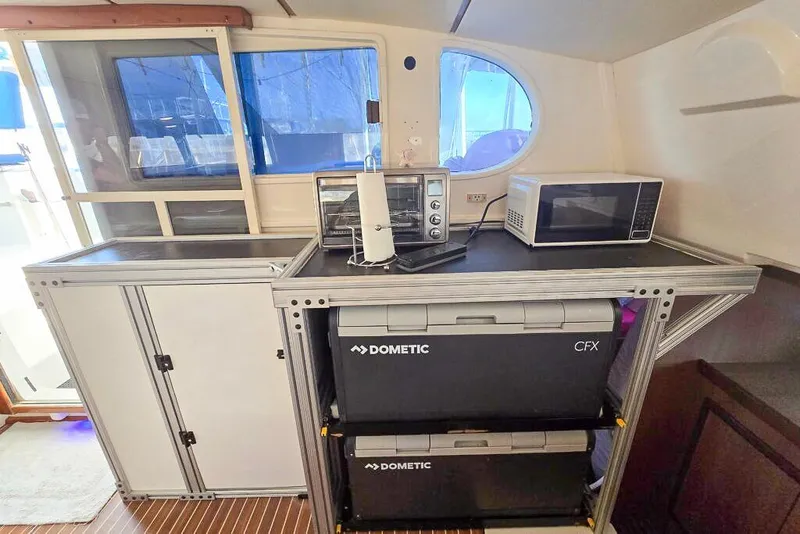 Slide: The Image of Compact kitchen area in a 2006 Dolphin 460 yacht with appliances and storage. - 47