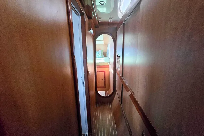 Slide: The Image of Narrow wooden hallway inside 2006 Dolphin 460 yacht, leading to a cozy cabin. - 49