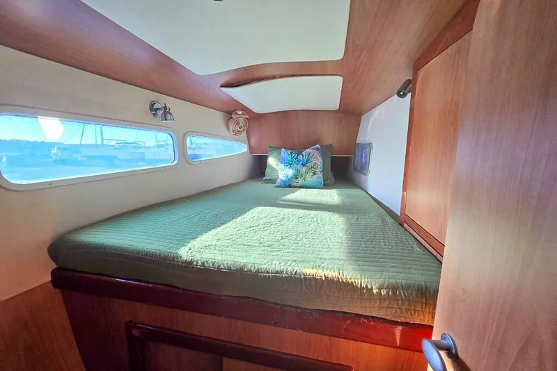 Slide: The Image of Cozy cabin interior of 2006 Dolphin 460 yacht with green bedding and porthole windows. - 50