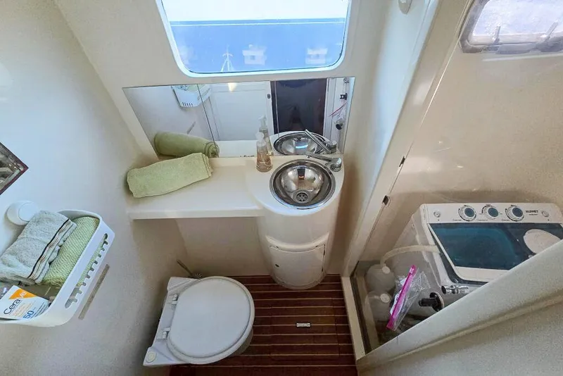 Slide: The Image of Compact bathroom in 2006 Dolphin 460 yacht with sink, toilet, and washing machine. - 52