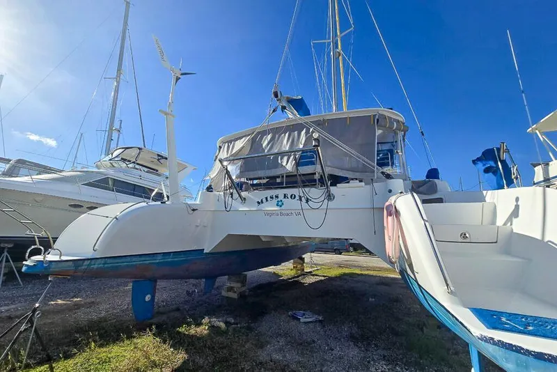Slide: The Image of 2006 Dolphin 460 catamaran on land, Virginia Beach, clear sky, sailboats in background. - 9
