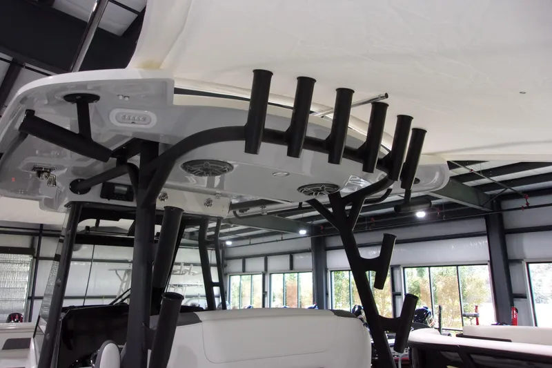 Slide: The Image of 2026 Cobia 305 Center Console boat interior with rod holders and speakers. - 16