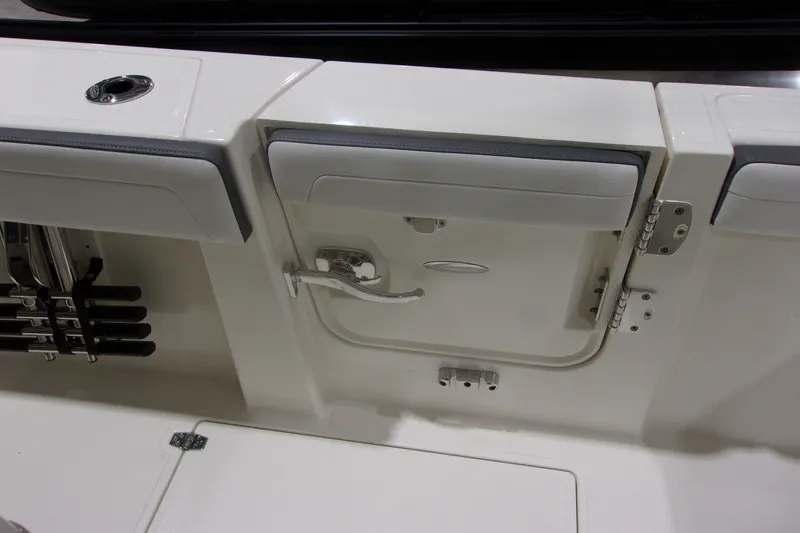 Slide: The Image of 2026 Cobia 305 Center Console boat interior with storage compartment and rod holders. - 18