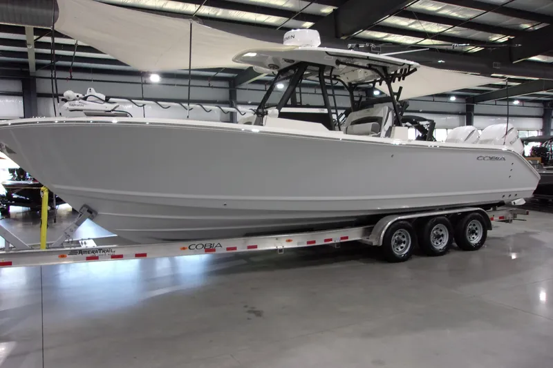 Slide: The Image of 2026 Cobia 305 Center Console boat on trailer in showroom. - 2