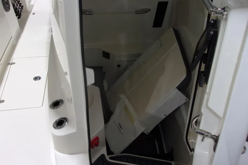 Slide: The Image of 2026 Cobia 305 Center Console interior storage compartment with open hatch. - 26