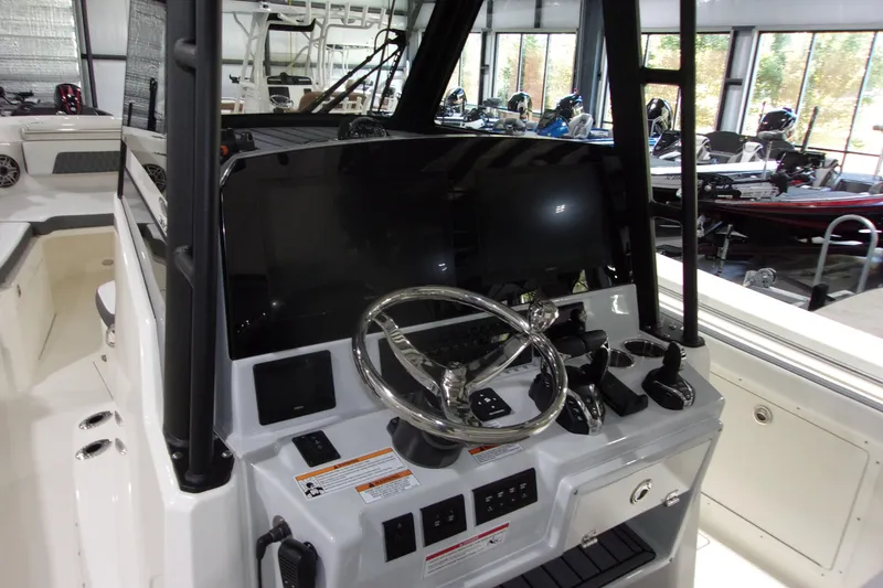 Slide: The Image of 2026 Cobia 305 Center Console boat dashboard with steering wheel and controls. - 4