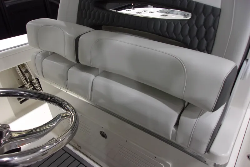 Slide: The Image of 2026 Cobia 305 Center Console boat interior with sleek steering wheel and cushioned seating. - 8