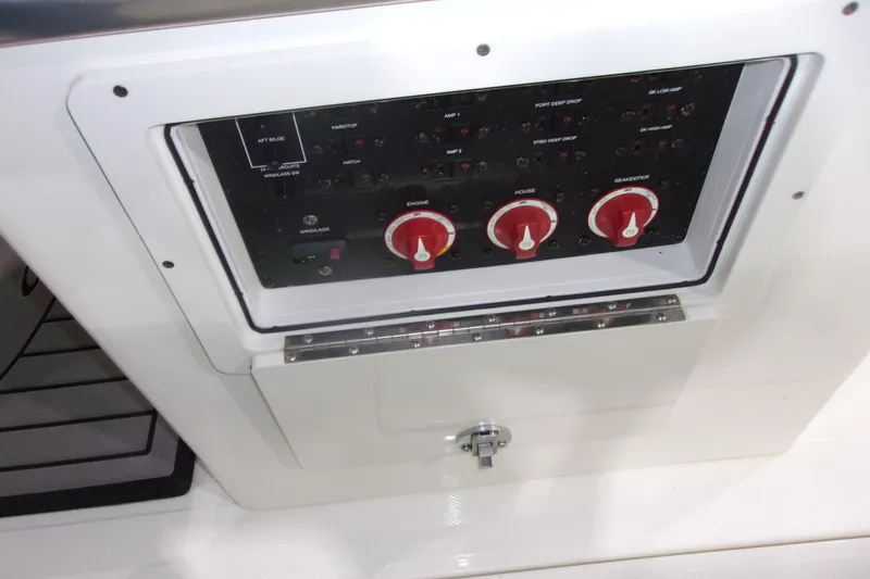 Slide: The Image of Control panel of 2026 Cobia 305 Center Console boat with red switches and labels. - 9