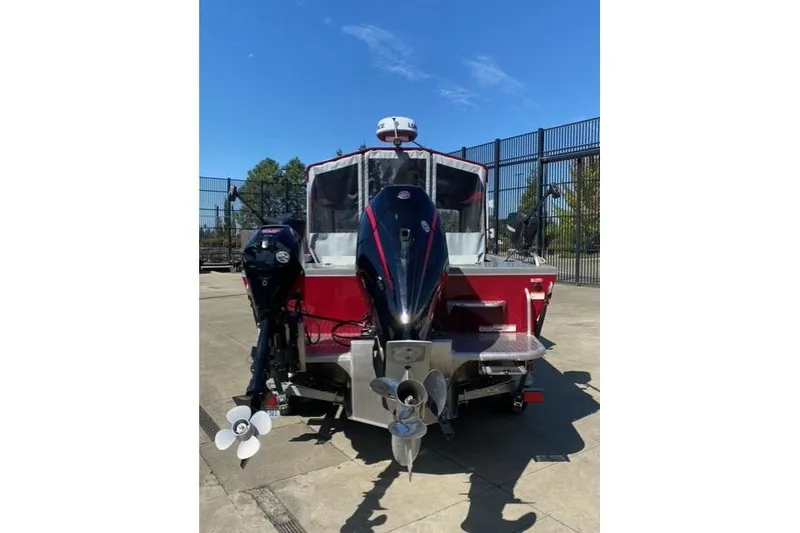 Slide: The Image of 2023 Spartan 200 Astoria boat with dual outboard motors on a sunny day. - 2