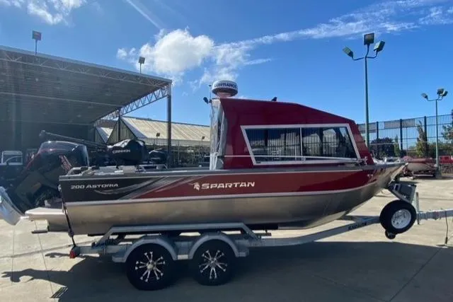 Slide: The Image of 2023 Spartan 200 Astoria boat on trailer, parked outdoors under clear sky. - 3