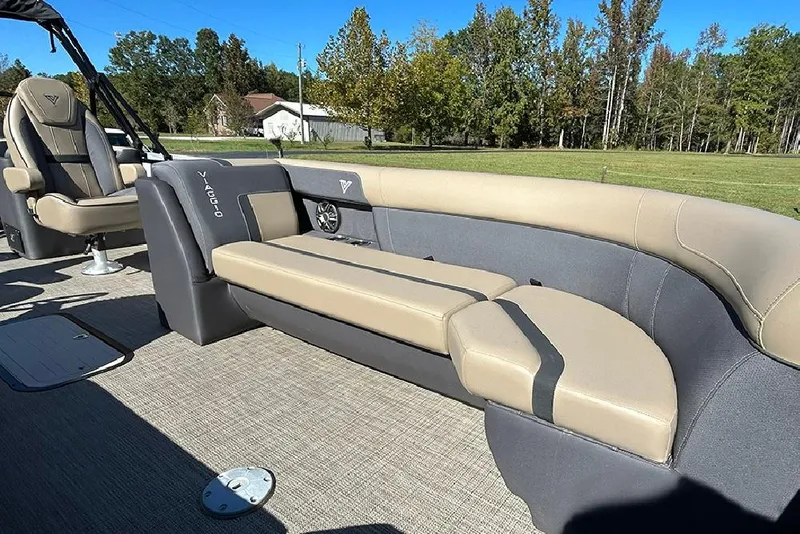 Slide: The Image of 2025 Viaggio Lago X-Q boat interior with beige and gray seating, surrounded by lush greenery. - 15