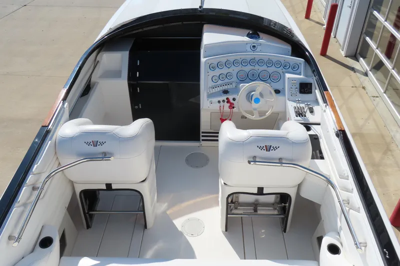 Slide: The Image of 1990 Wellcraft 38 Scarab boat cockpit with white seats and detailed control panel. - 11