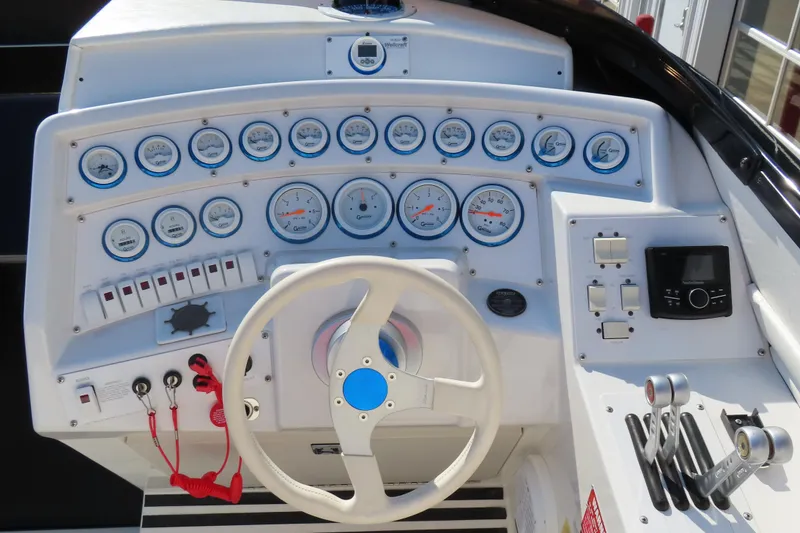 Slide: The Image of 1990 Wellcraft 38 Scarab dashboard with gauges, steering wheel, and control levers. - 12