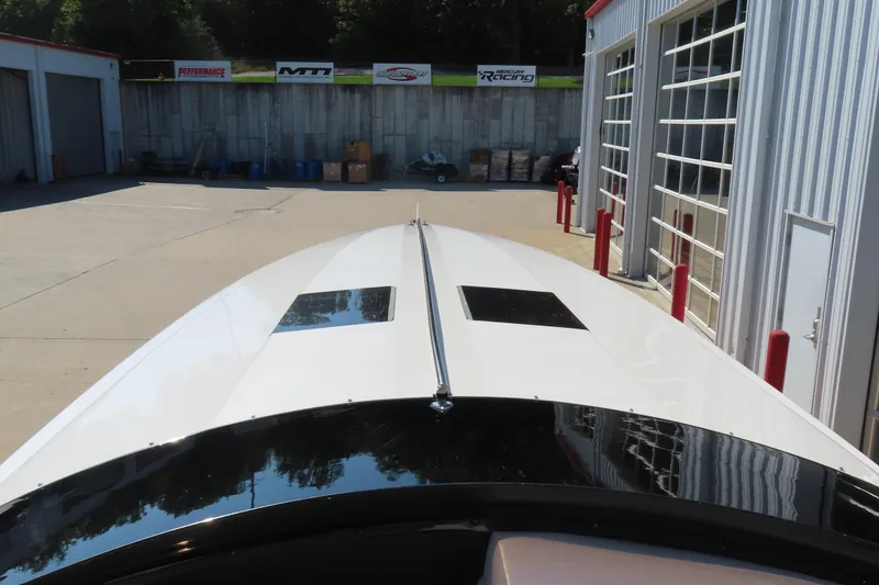 Slide: The Image of 1990 Wellcraft 38 Scarab boat parked near a garage with performance banners. - 27