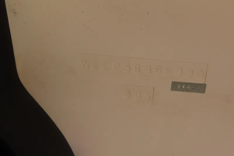 Slide: The Image of 1990 Wellcraft 38 Scarab hull identification number on beige surface. - 29