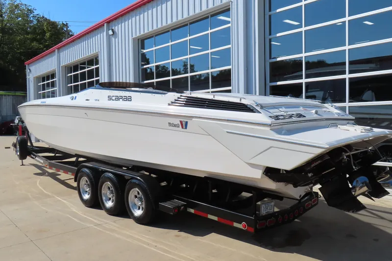 Slide: The Image of 1990 Wellcraft 38 Scarab boat on a trailer outside a modern garage. - 4