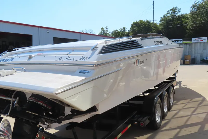 Slide: The Image of 1990 Wellcraft 38 Scarab boat on trailer, parked outdoors near a building. - 7