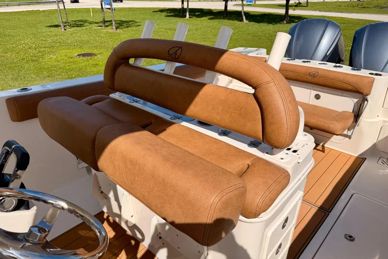 Slide: The Image of 2015 Sailfish 290 CC boat interior with tan seating and dual engines. - 15