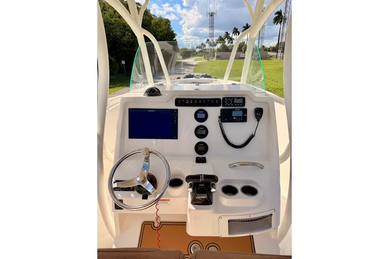 Slide: The Image of 2015 Sailfish 290 CC boat dashboard with steering wheel and navigation controls. - 17