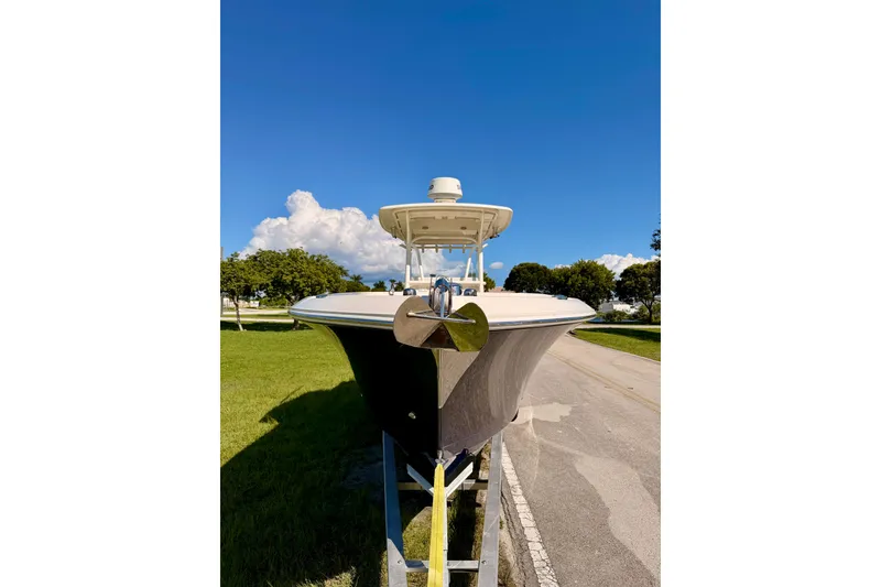 Slide: The Image of 2015 Sailfish 290 CC boat on trailer under clear blue sky. - 2