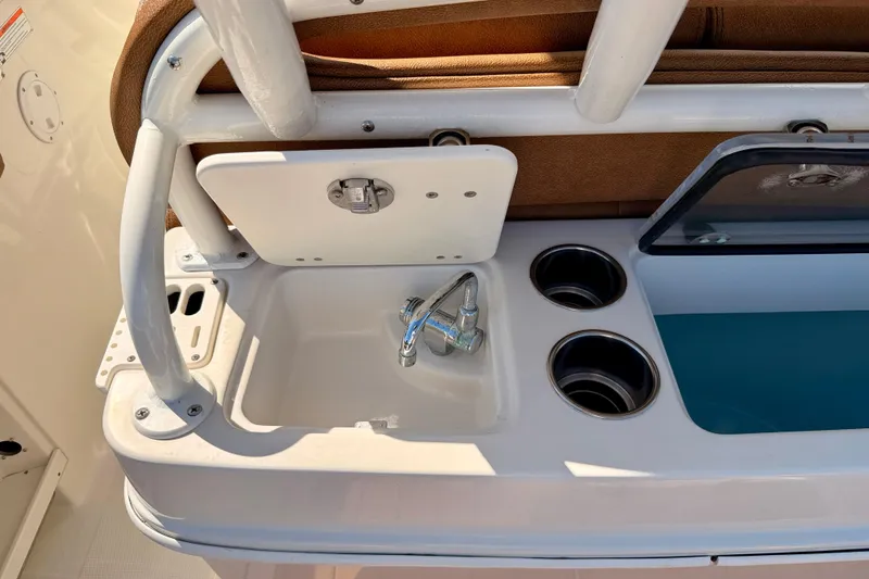 Slide: The Image of 2015 Sailfish 290 CC boat sink and cup holders on deck. - 25