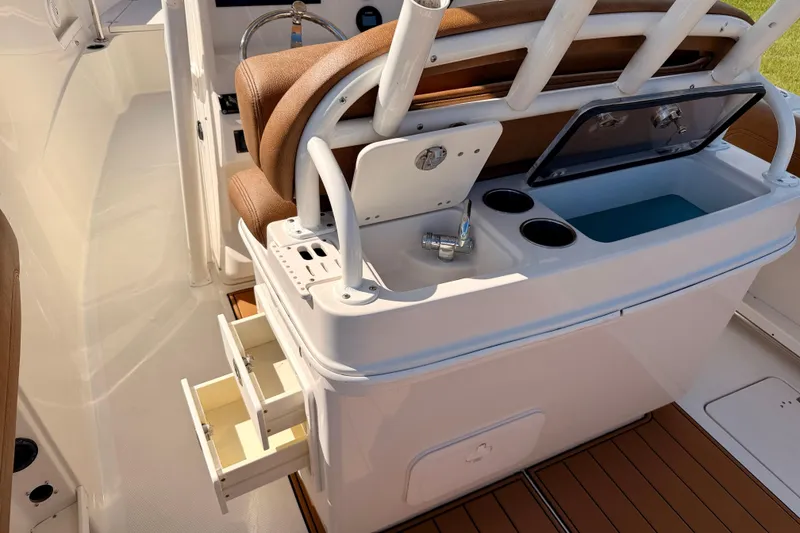 Slide: The Image of 2015 Sailfish 290 CC boat interior with seating, storage drawers, and sink. - 27
