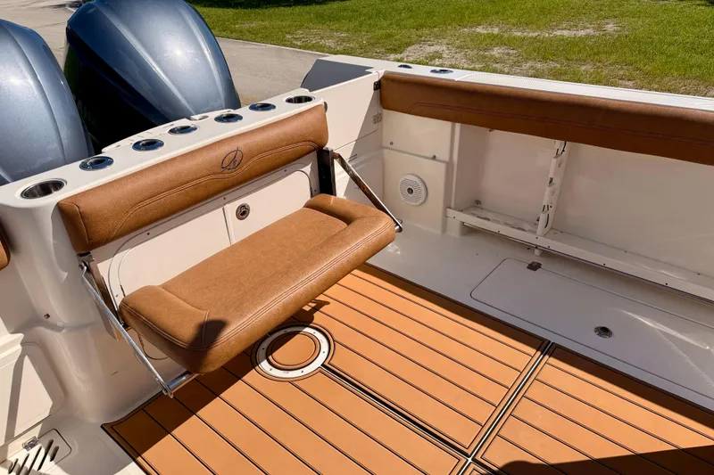 Slide: The Image of 2015 Sailfish 290 CC boat interior with brown seating and teak-style flooring. - 31