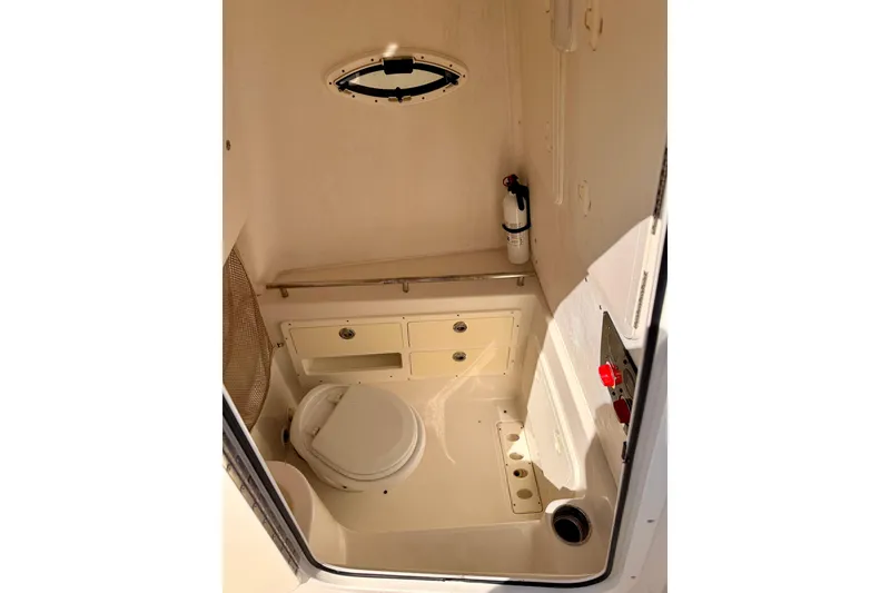 Slide: The Image of 2015 Sailfish 290 CC boat interior with toilet and storage compartments. - 33