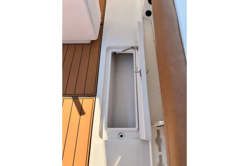 Slide: The Image of Open storage compartment on 2015 Sailfish 290 CC boat deck with brown and white finish. - 36