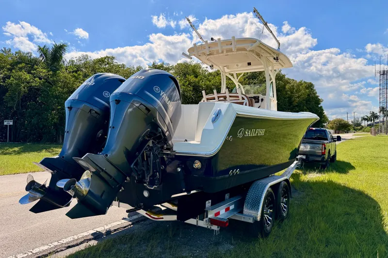 Slide: The Image of 2015 Sailfish 290 CC boat with dual Yamaha engines on trailer, sunny day. - 5