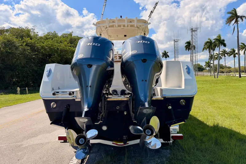 Slide: The Image of 2015 Sailfish 290 CC boat with dual 300 horsepower engines, parked on a sunny day. - 6