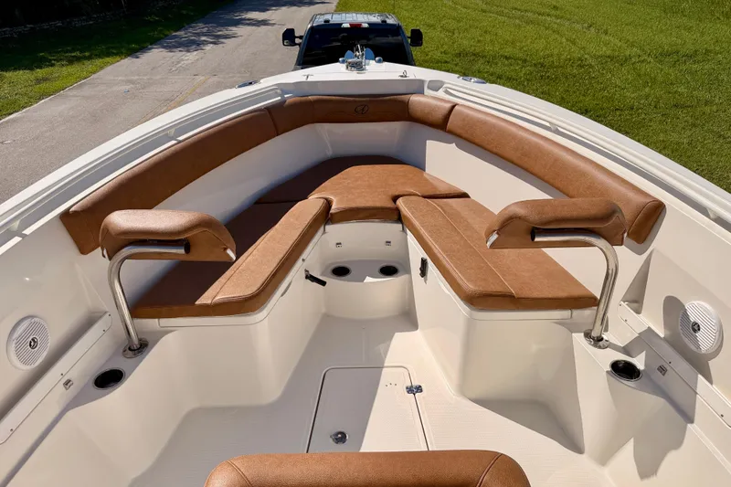 Slide: The Image of 2015 Sailfish 290 CC boat interior with brown cushioned seating and stainless steel handrails. - 8