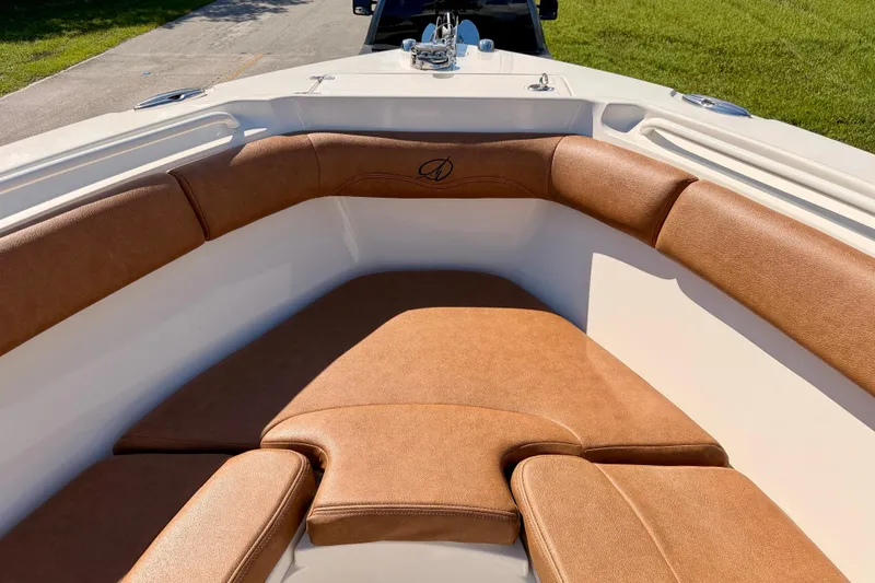 Slide: The Image of 2015 Sailfish 290 CC boat interior with brown cushioned seating. - 9