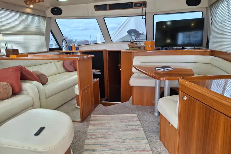 Slide: The Image of Interior of 2000 Riviera Enclosed Flybridge yacht with cozy seating and TV. - 10