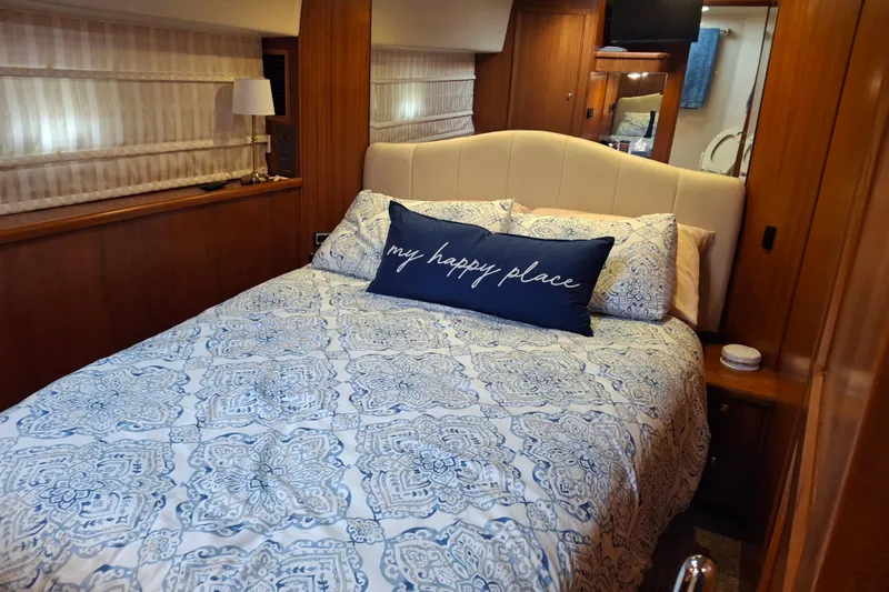 Slide: The Image of Bathroom interior of 2000 Riviera Enclosed Flybridge yacht with wooden accents and blue towels. - 18