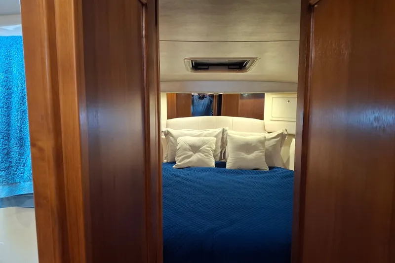 Slide: The Image of Interior cabin of 2000 Riviera Enclosed Flybridge with cozy bed and storage cabinets. - 25