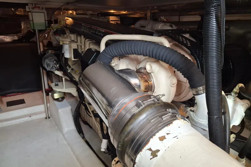 Slide: The Image of Engine compartment of a 2000 Riviera Enclosed Flybridge yacht, showcasing hoses and components. - 30