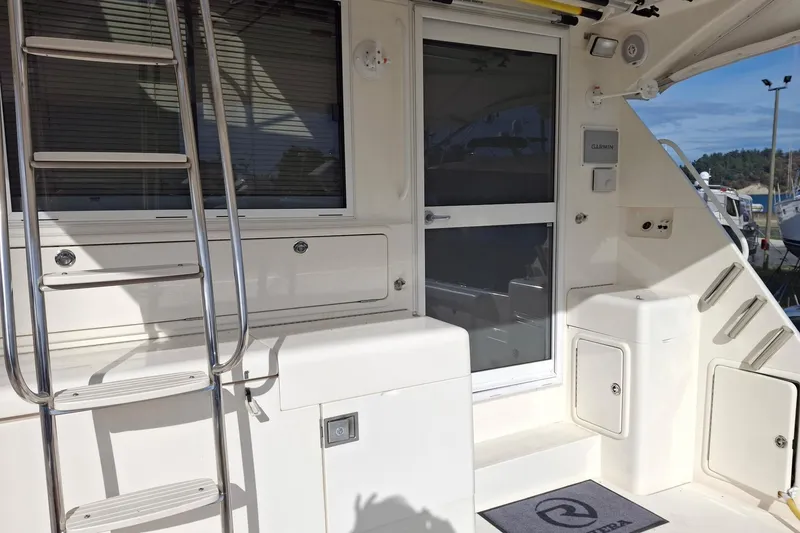 Slide: The Image of 2000 Riviera Enclosed Flybridge yacht interior with storage compartments and marina view. - 4