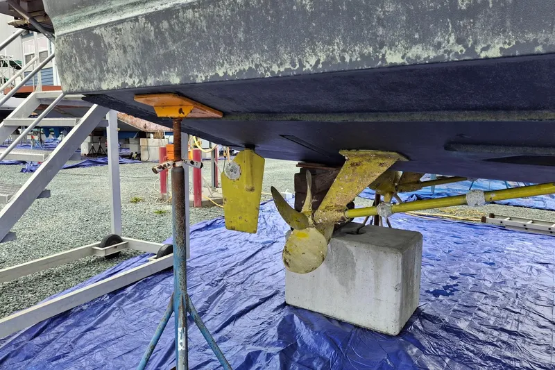 Slide: The Image of 2000 Riviera Enclosed Flybridge yacht on dry dock with visible propellers and maintenance setup. - 46