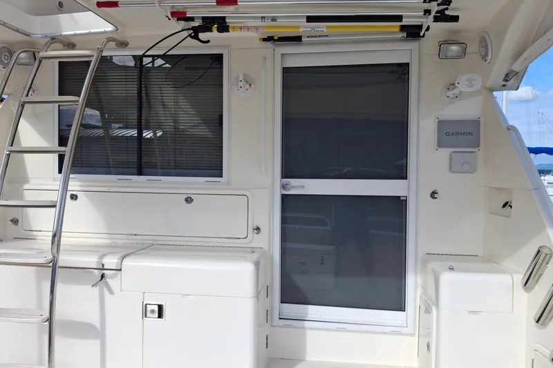 Slide: The Image of Luxurious interior of 2000 Riviera Enclosed Flybridge yacht with white leather seating and red cushions. - 8