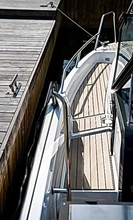 Slide: The Image of 2025 Yamarin 80DC boat docked, showcasing sleek design and wooden deck. - 20