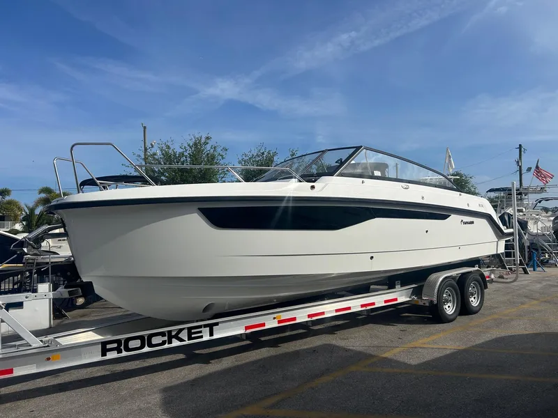 Slide: The Image of 2025 Yamarin 80DC boat on trailer under clear blue sky. - 26