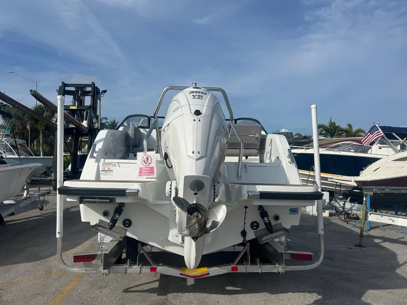 Slide: The Image of 2025 Yamarin 80DC boat, rear view, docked with outboard motor, clear sky background. - 31