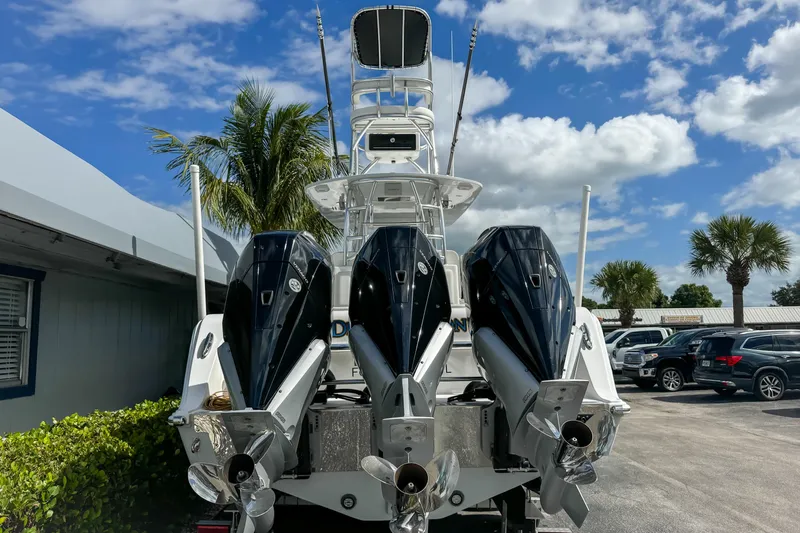 Slide: The Image of 2023 Front Runner 36 Center Console boat with triple outboard engines, parked outdoors. - 5