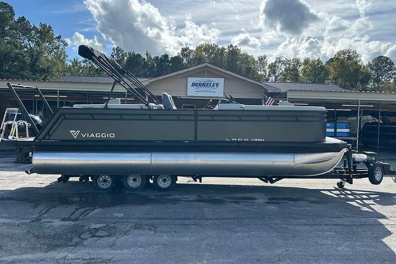 Slide: The Image of 2025 Viaggio Lago V-U pontoon boat on trailer, parked outside dealership. - 5